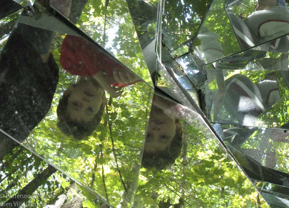 A boy is turned upside down as he looks into the mirror.  