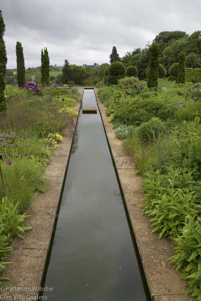 A canal moves through dense plantings at Broughton Grange in England. 