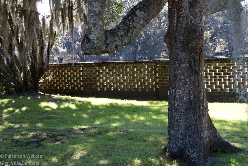 A pierced brick wall separates the garden from the working sections of the plantation.