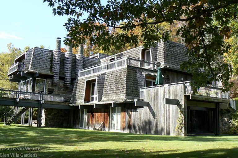 This view of the house shows the barnboard siding, the cedar-shingled roof, the round chimneys and two of the six decks that surround the house.