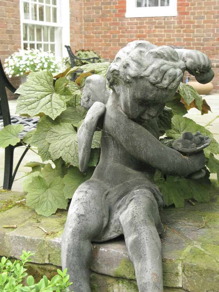 This stone cupid sits on a garden wall at Mt Cuba, a garden in Delaware that showcases wildflowers in their natural setting.