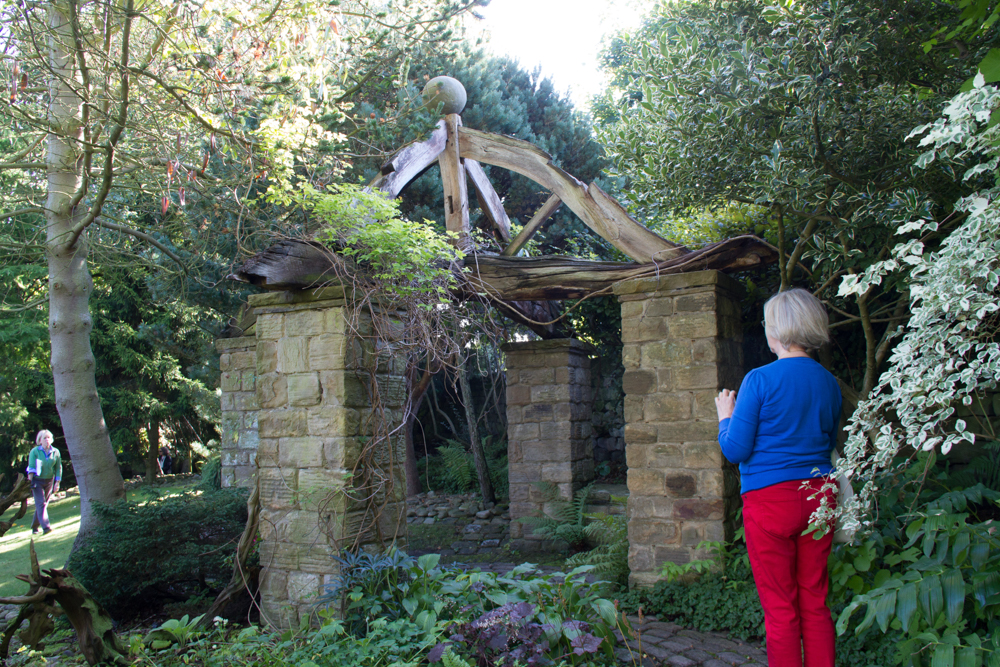 Two visitors to York Gate in examine both sides of a garden structure. 