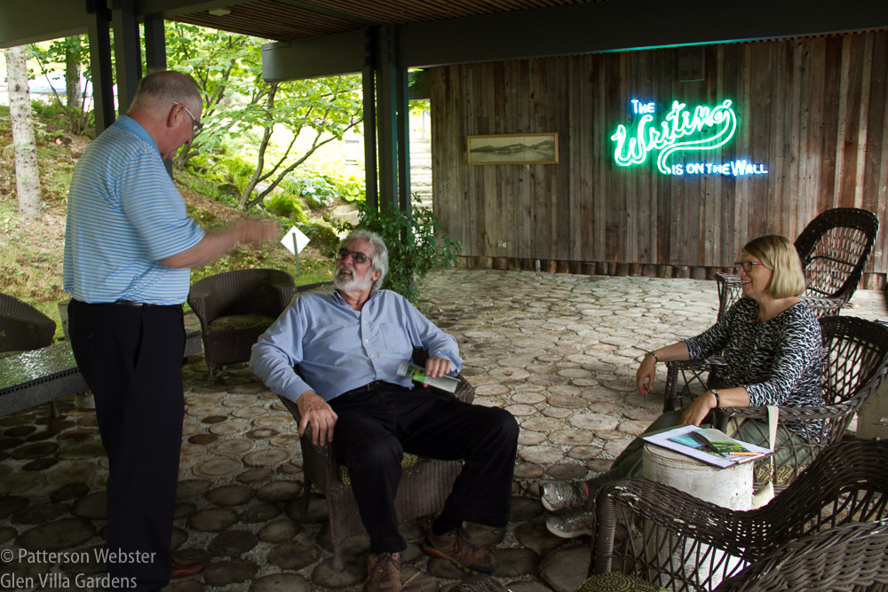 Old friends and new gathered to talk on the Log Terrace. In the background beside the neon sign is a photograph of Glen Villa Inn, the resort hotel that stood on the property until it burned in 1909.